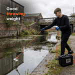 Lifestyle image of Cube 360° fishing magnet in use along a canal, showing balanced throwing weight for accurate magnet fishing.