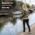 Lifestyle image of a woman magnet fishing by a harbor, showing beginner to advanced friendly outdoor use.
